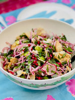 pomegranate and broad bean salad in large bamboo bowl decorated in green turtles
