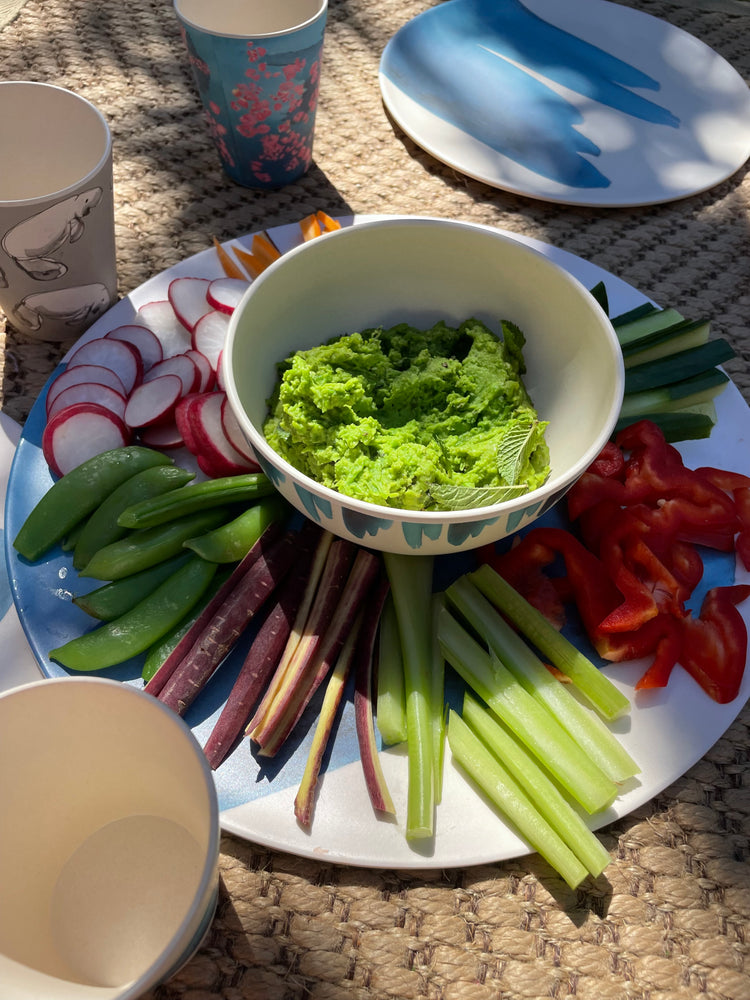 Pea and mint dip in blue bamboo bowl  with vegetable crudités patter made from bamboo. This beautiful platter has a striking blue wave print and is good serving food at a drinks party , cakes, cheese or fruit.