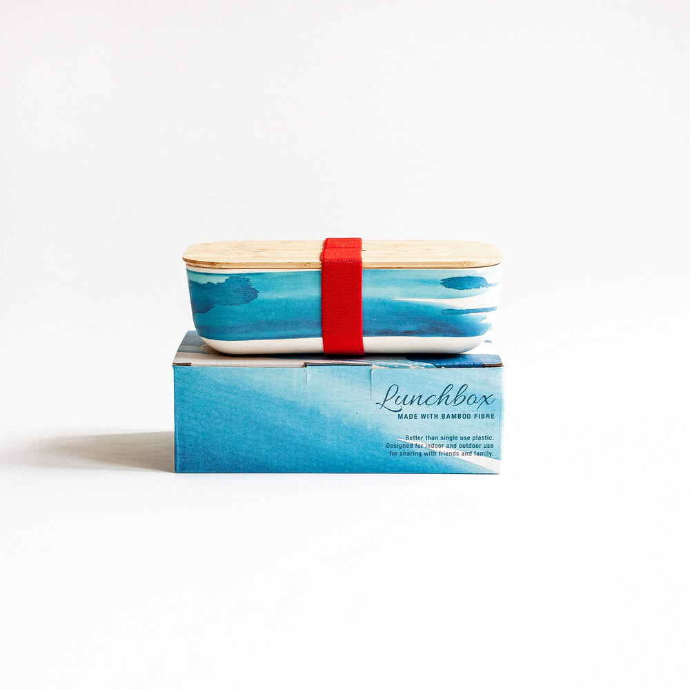  lunch box  with red strap and blue wave print on printed gift box with blue wave design 