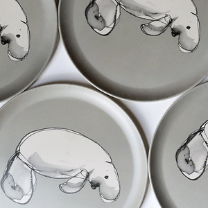 
                  
                    close up of four bamboo plates with dugong design 
                  
                
