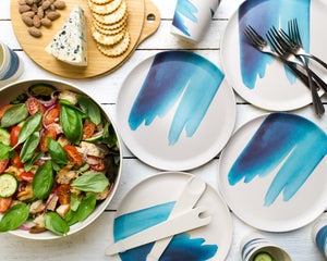 
                  
                    modern blue wave printed plates with tomato basil salad and cheese platter on wooden chopping board lid
                  
                