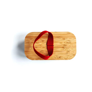 
                  
                    bamboo lunch box lid with red elastic fastening
                  
                