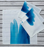 set of four organic cotton napkins 42cm by 42cm with blue wave prints. 