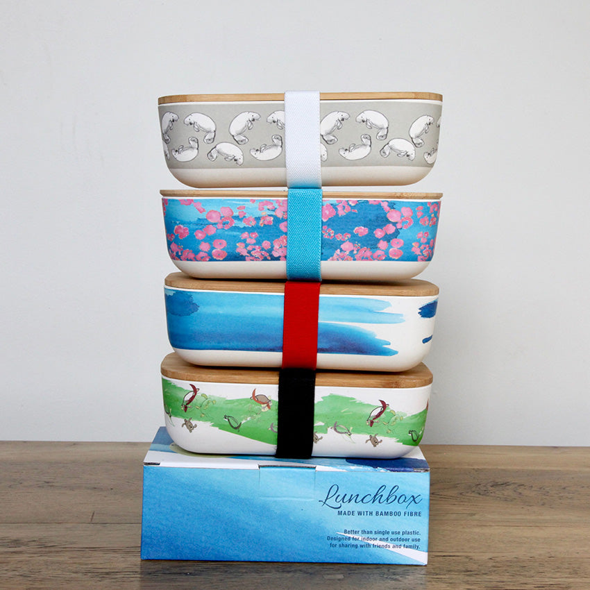 
                  
                    four lunch boxes stacked in tower with printed designs
                  
                